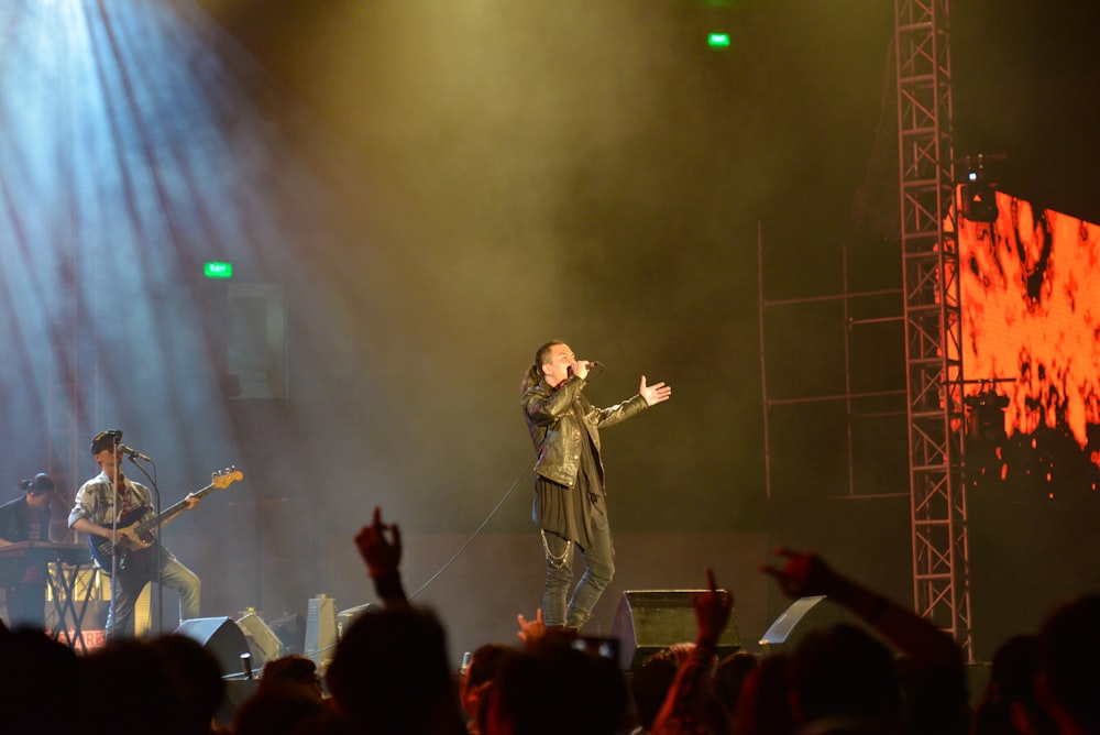 man in black leather jacket using wireless microphone