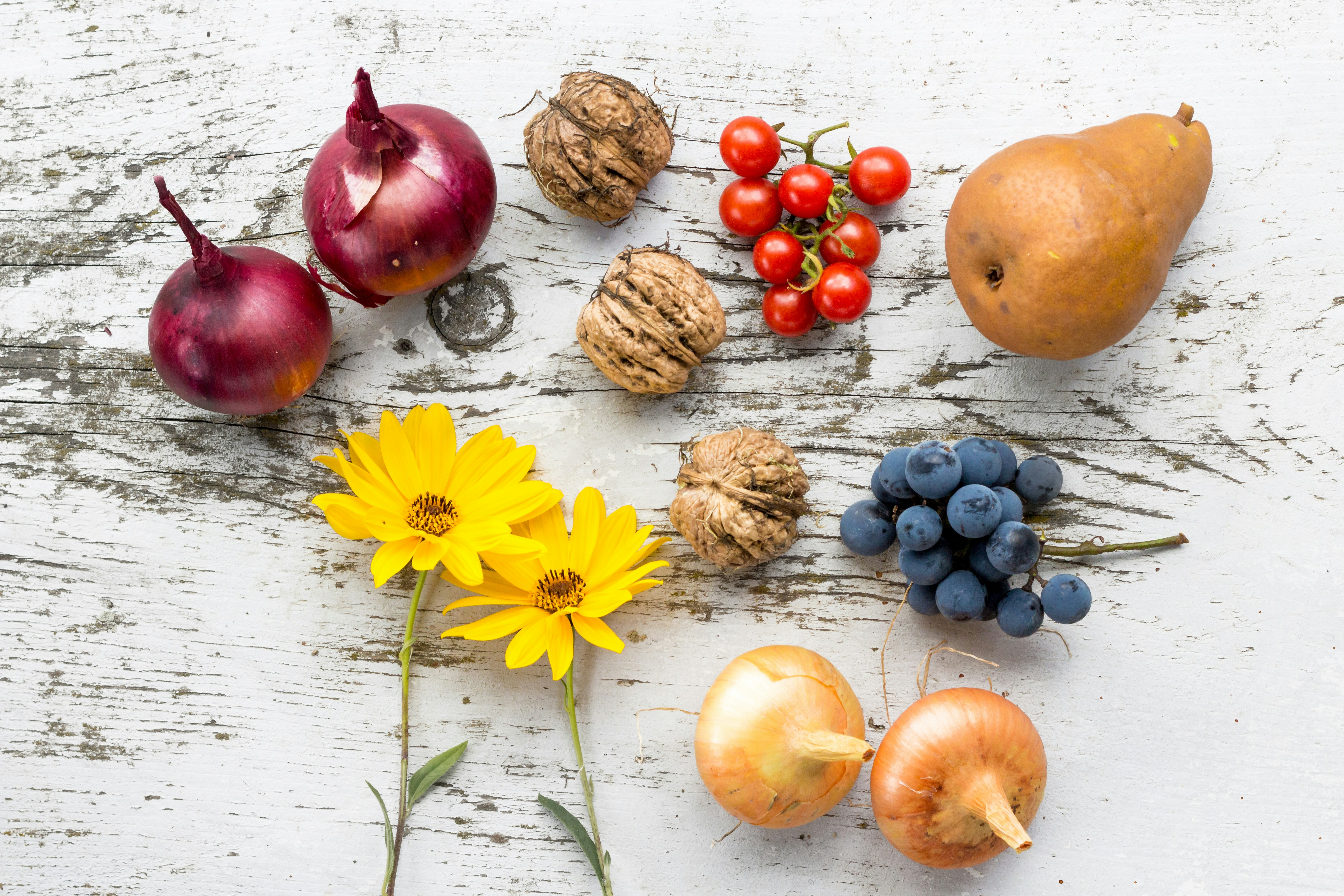 assorted vegetables, fruits, and flowers on white surface