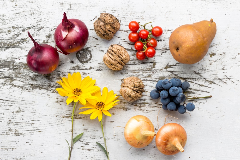 assorted vegetables, fruits, and flowers on white surface