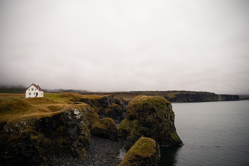 white and brown houses on cliff facing sea