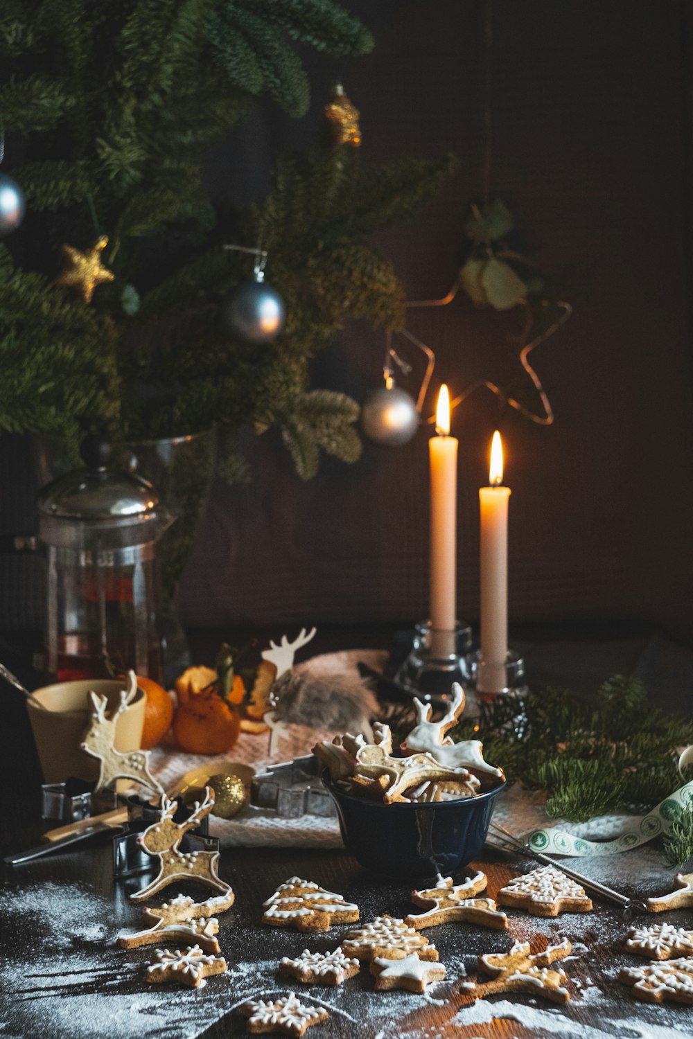 two lighted taper candles beside Christmas tree