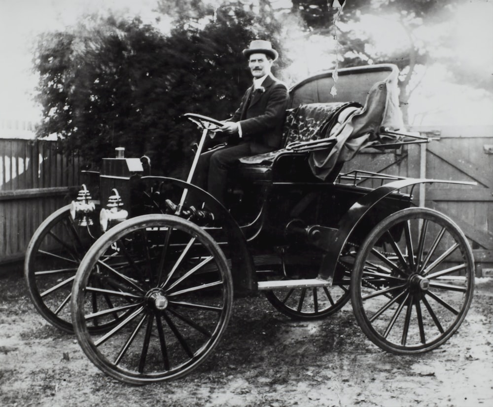 grayscale photo of man riding vehicle