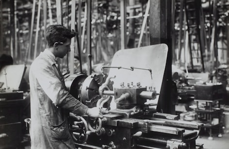 A skilled worker operating heavy machinery in a fabrication shop.