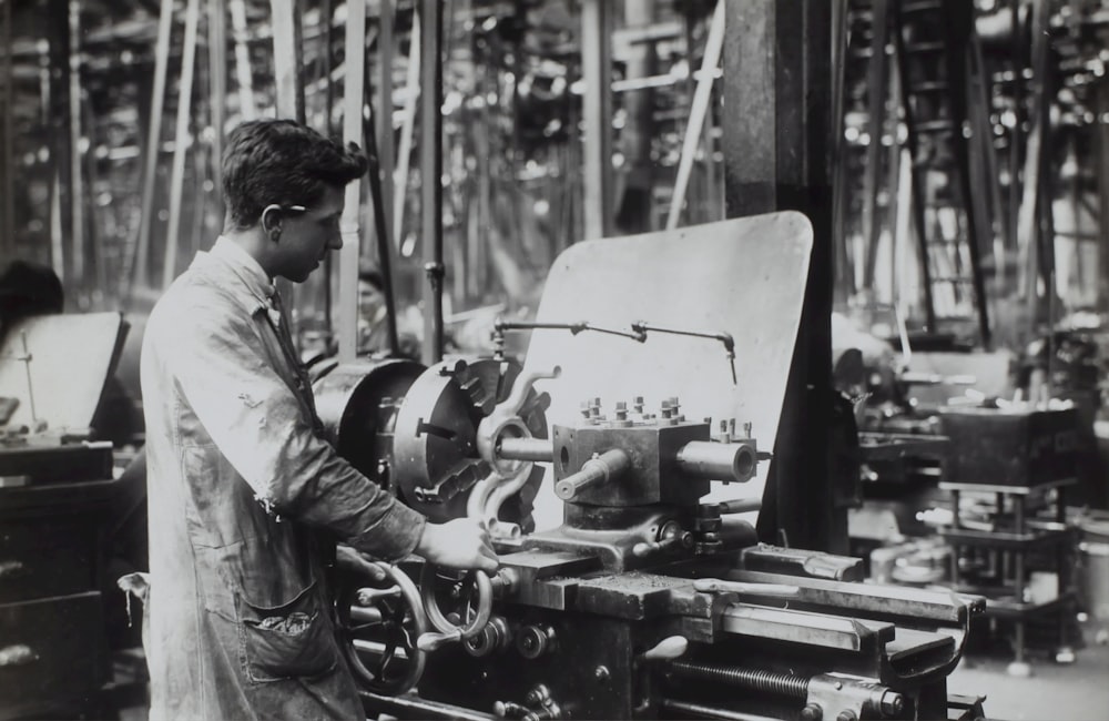 Homme debout devant une machine mécanique