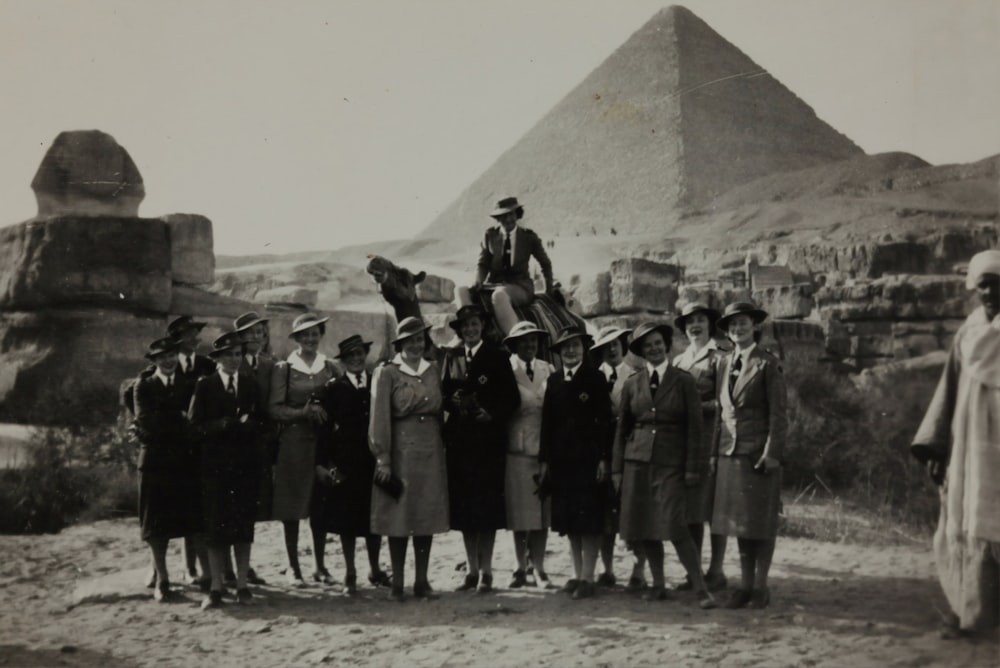 ピラミッドの前に立つ女性のグループのグレースケール写真