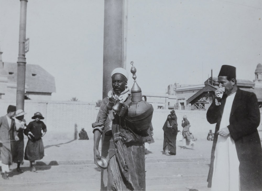 grayscale photo of man carrying jar