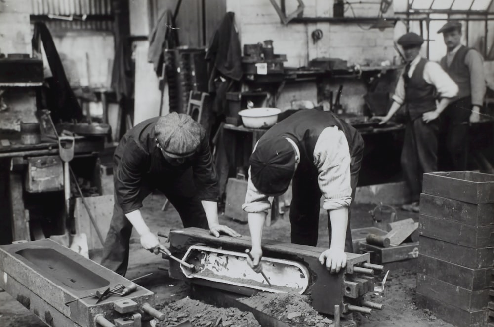 grayscale photo of two men cleaning container