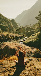 person meditating on cliff