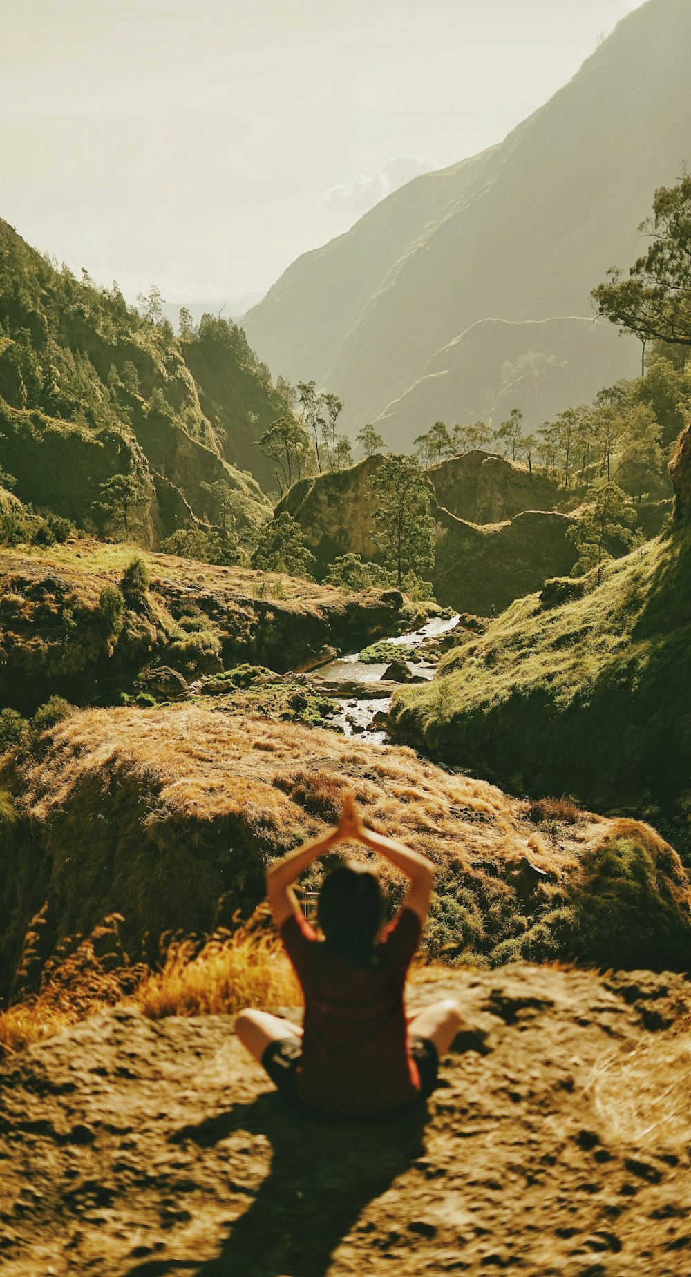 person meditating on cliff