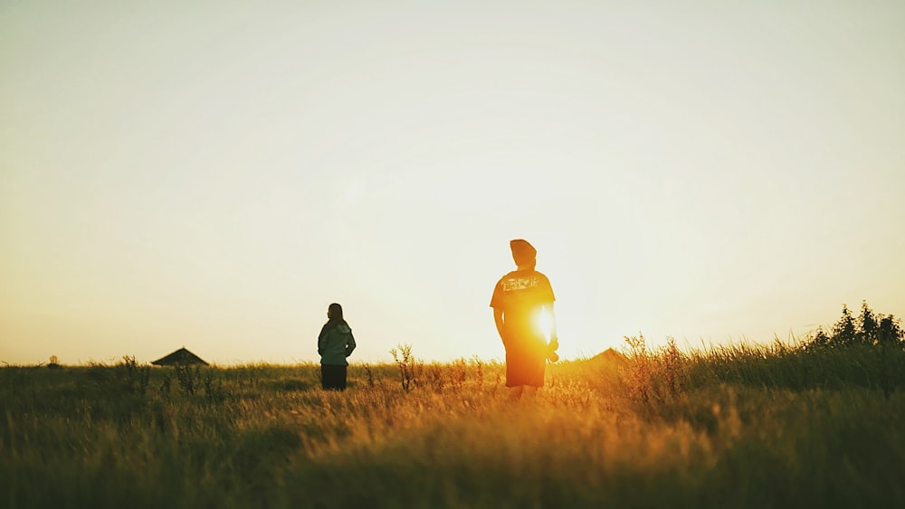 silhouette of two people on grassfield