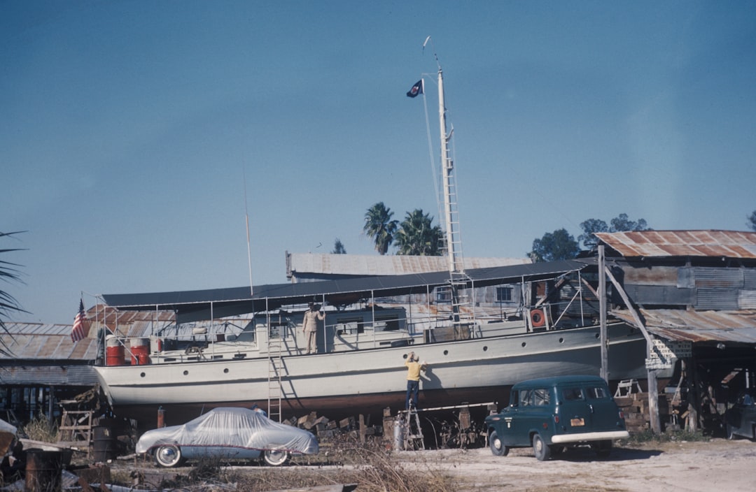 white cabin boat on top of two cars