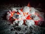 Cube-shaped coconut charcoal briquettes glowing softly in a shisha bowl.