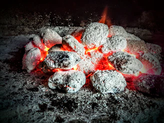 Close-up of glowing coconut shell charcoal briquettes stacked neatly