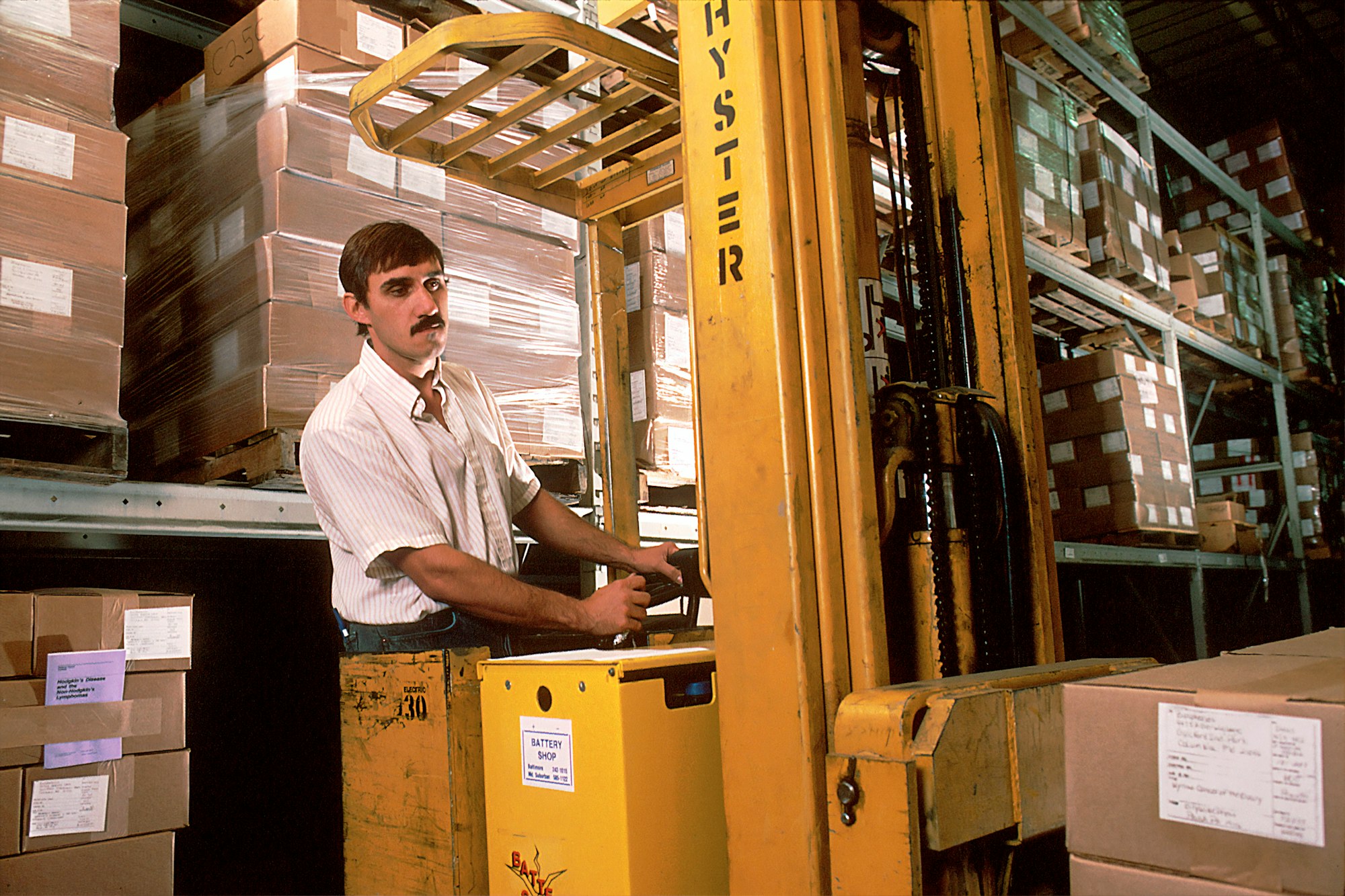 A man driving a fork lift in the warehouse that was once used for the storage and distribution of NCI publications ordered through the NCI Cancer Information Service (CIS). 1988