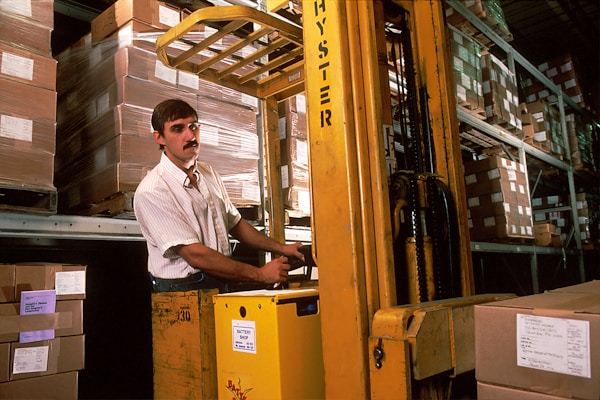 A man driving a fork lift in the warehouse that was once used for the storage and distribution of NCI publications ordered through the NCI Cancer Information Service (CIS). 1988by National Cancer Institute