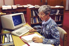 woman sitting at desk with desktop computer