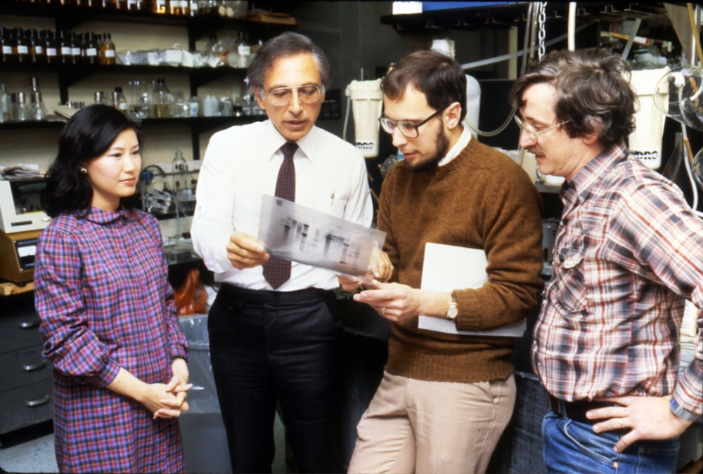 three men standing beside woman