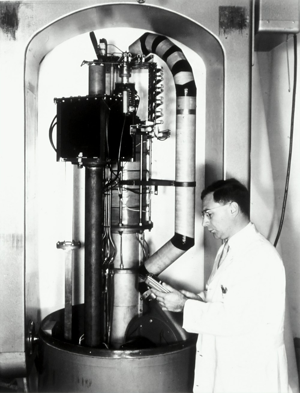 man standing infront of scientific machine
