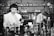 Two individuals are in a laboratory setting, surrounded by various laboratory equipment and chemical bottles. One person is working with a balance scale, while the other appears to be sitting or leaning on a bench in the background. Shelves filled with glass bottles line the wall behind them.