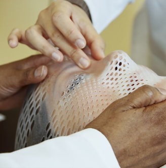 person holding man's face during operation