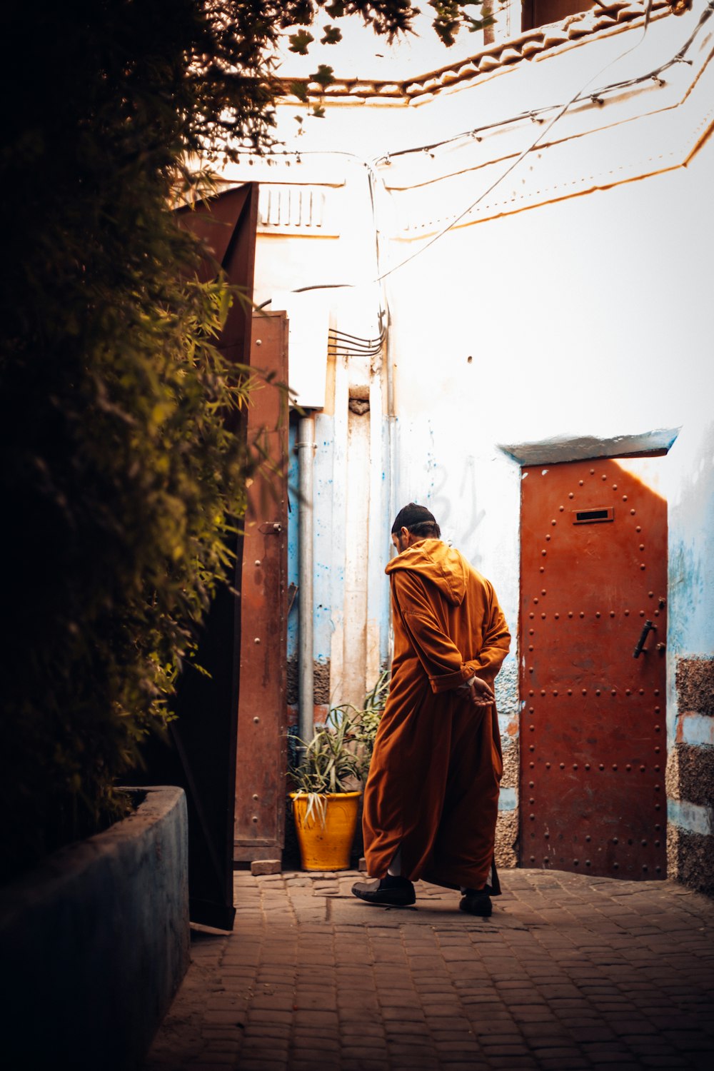 man standing beside brown door\]