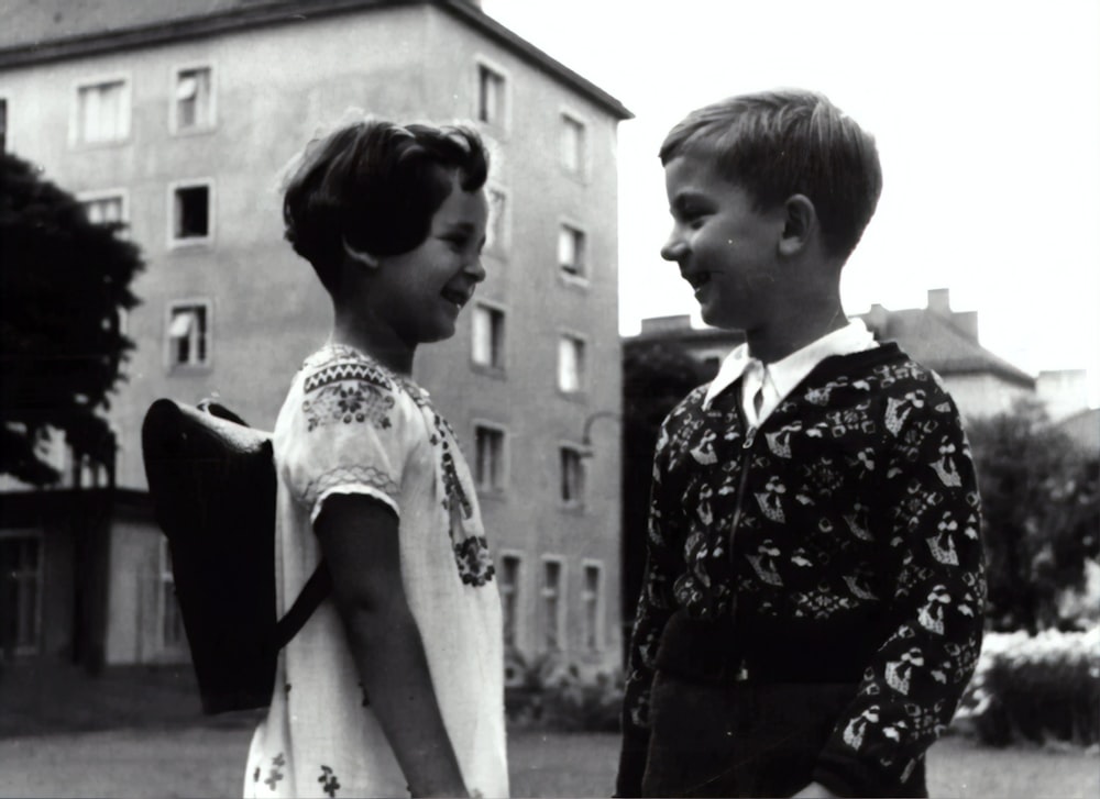 grayscale photography of boy and girl facing each other