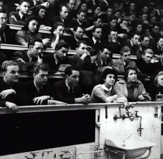 grayscale photography of people sitting on crowd chair