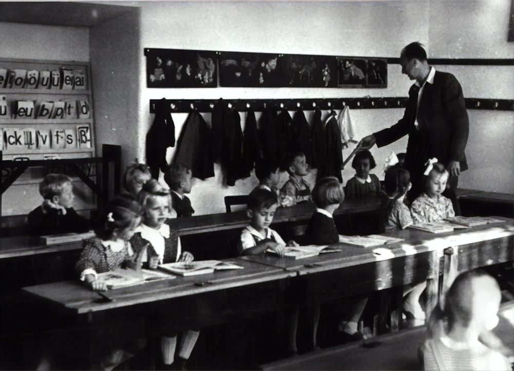 grayscale photography of children sitting inside room