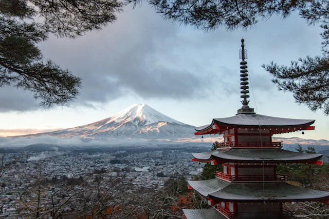 Red pagoda with Mount Fuji rising behind it, Japan