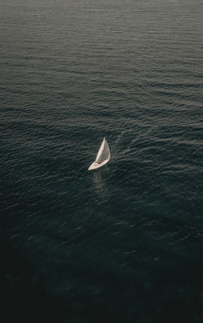 white sailing boat on body of water