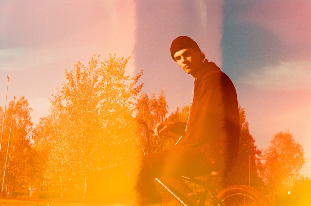 a man riding a bike down a street next to a forest