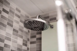Shiny stainless steel shower heads mounted on a tiled wall