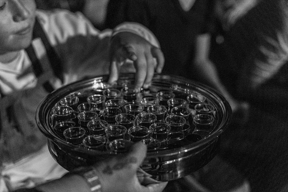 greyscale photo of boy holding round tray