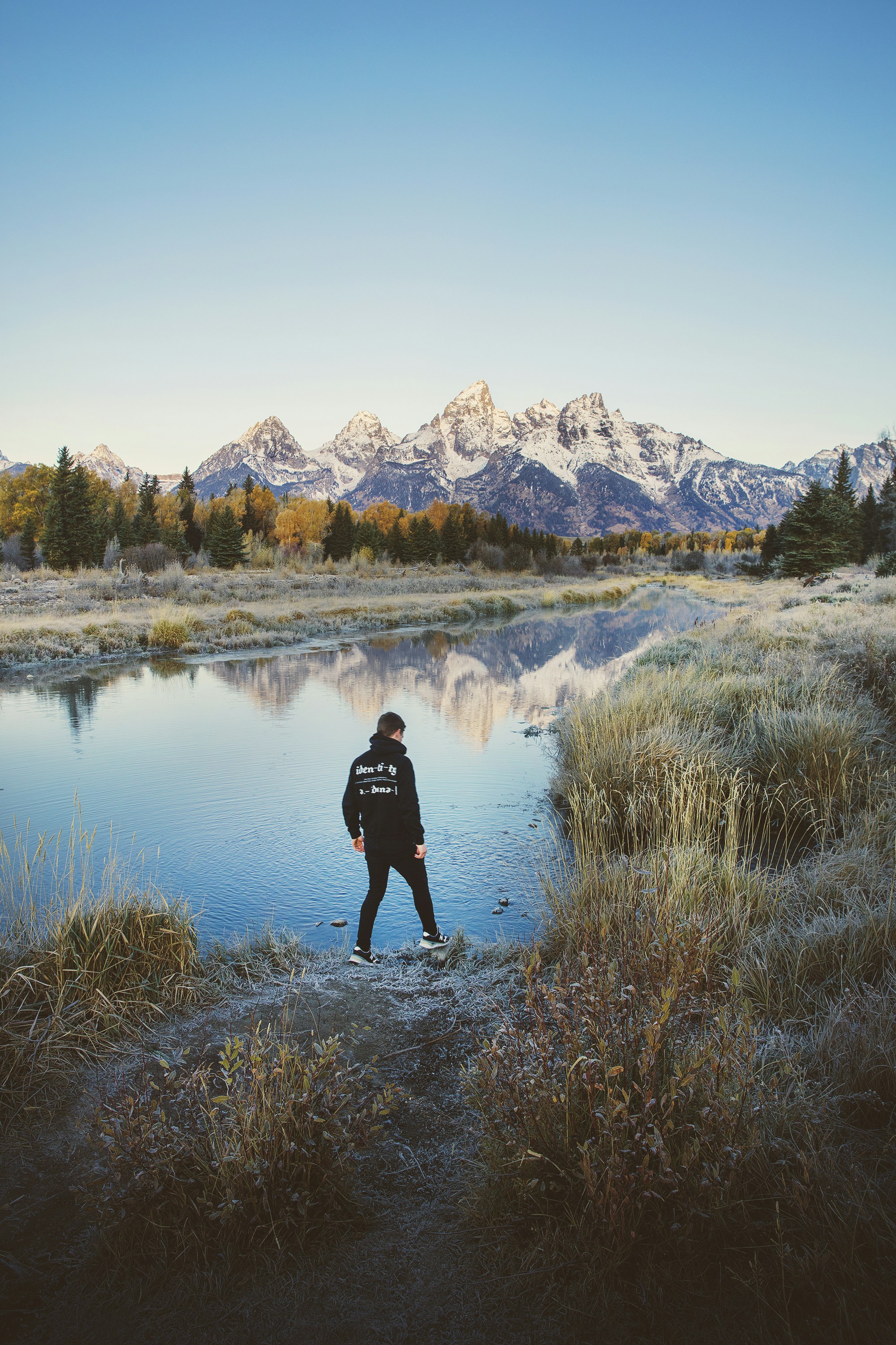 man standing beside body of water