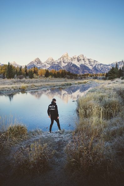 man standing beside body of water