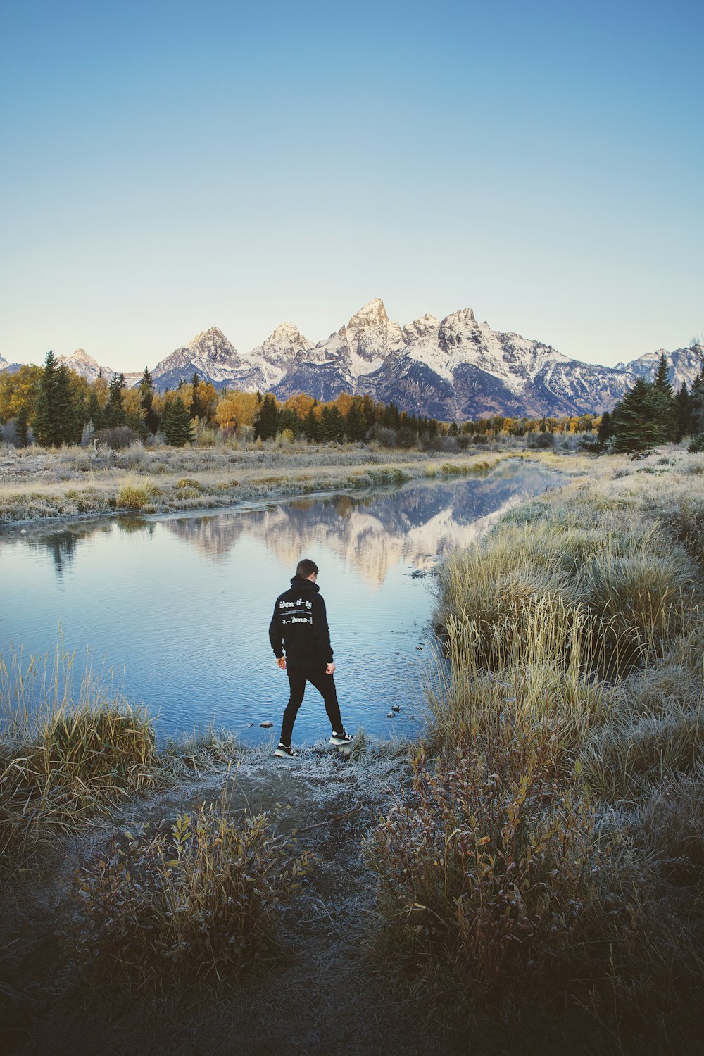 man standing beside body of water