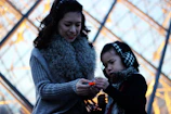 A smiling mother and child exploring a children’s museum exhibit.
