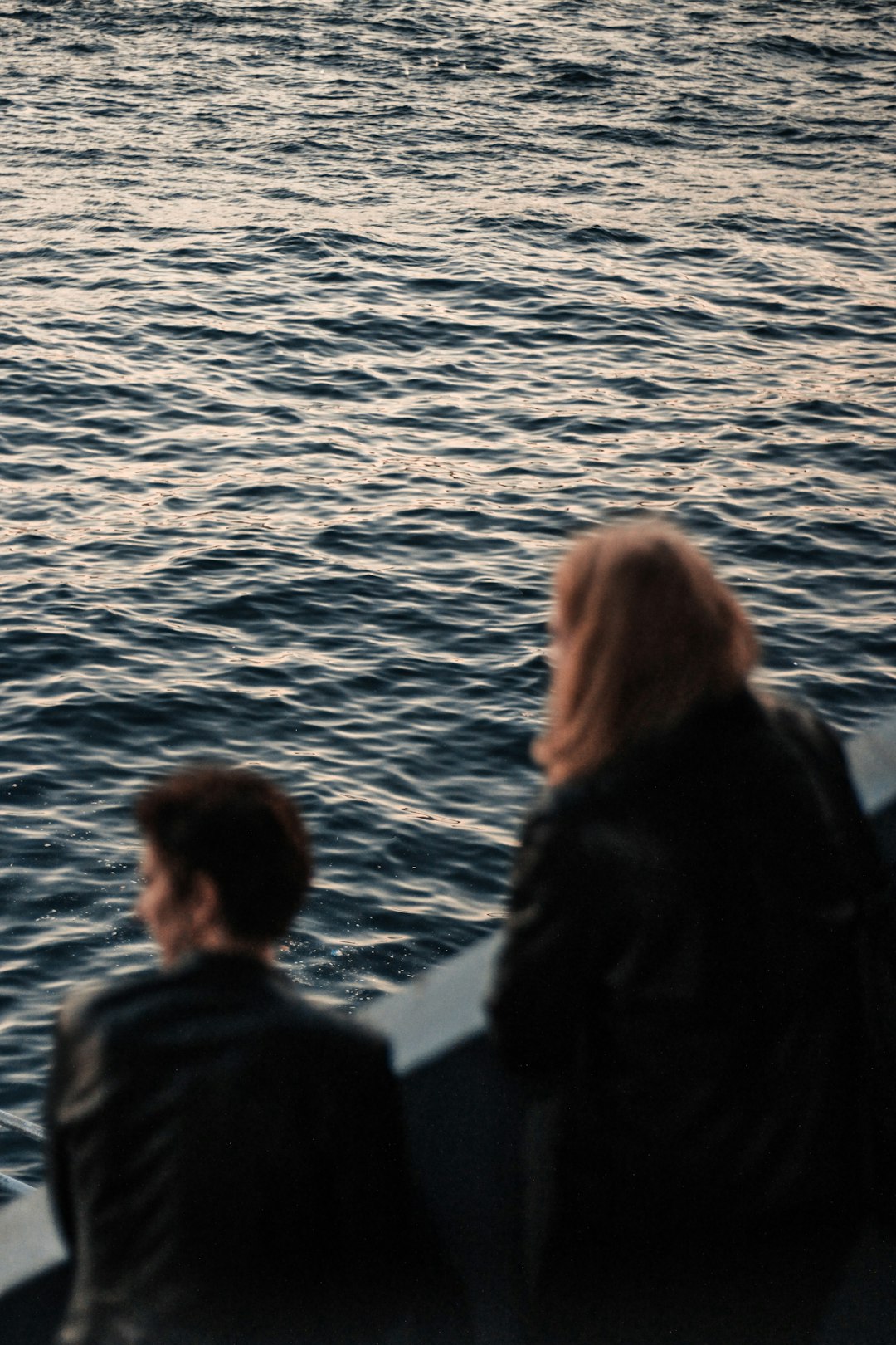 shallow focus photo of person looking at body of water during daytiem