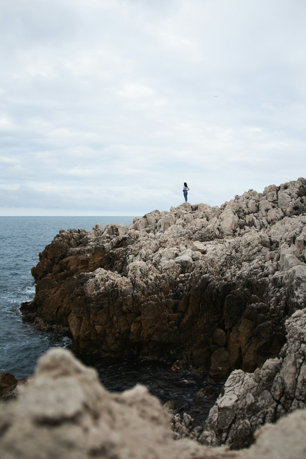 Photo de mise au point peu profonde d’une personne debout sur une falaise pendant la trime diurne