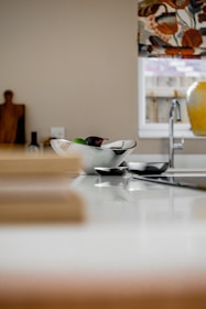 Bright kitchen scene with vibrant fruits and snack bowls on the counter.