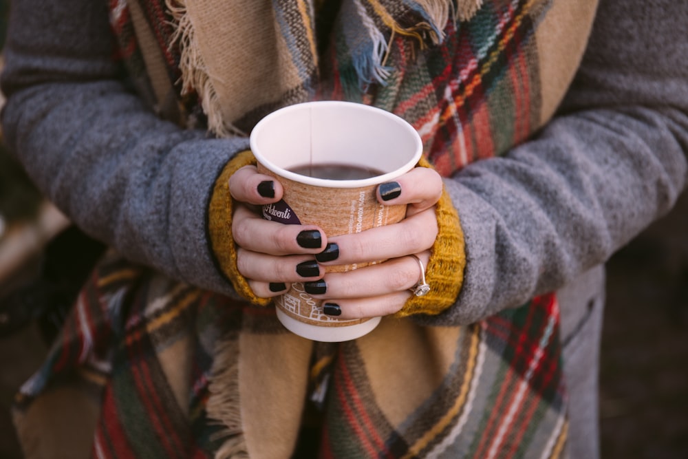 femme tenant une tasse de café