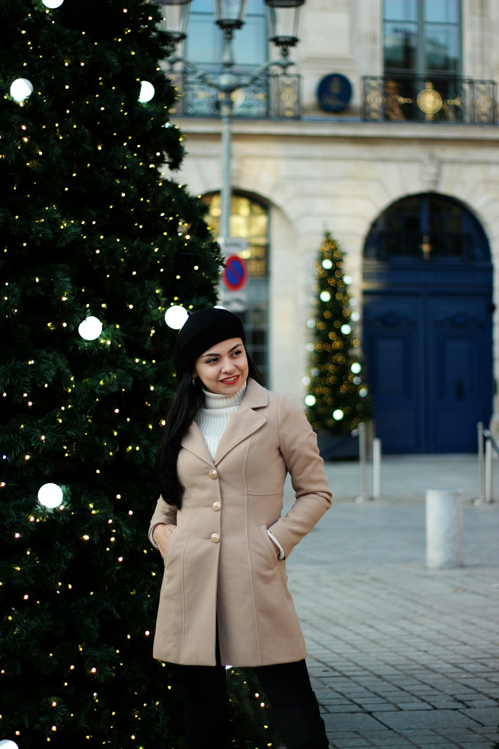 woman standing beside a Christmas tree