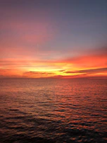 A breathtaking sunset over the calm Mediterranean, reflected on the water.