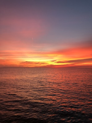 A vibrant sunset over a calm sea, capturing tranquility.