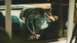 A friendly instructor explaining driving concepts to a learner in a calm, well-lit car interior.