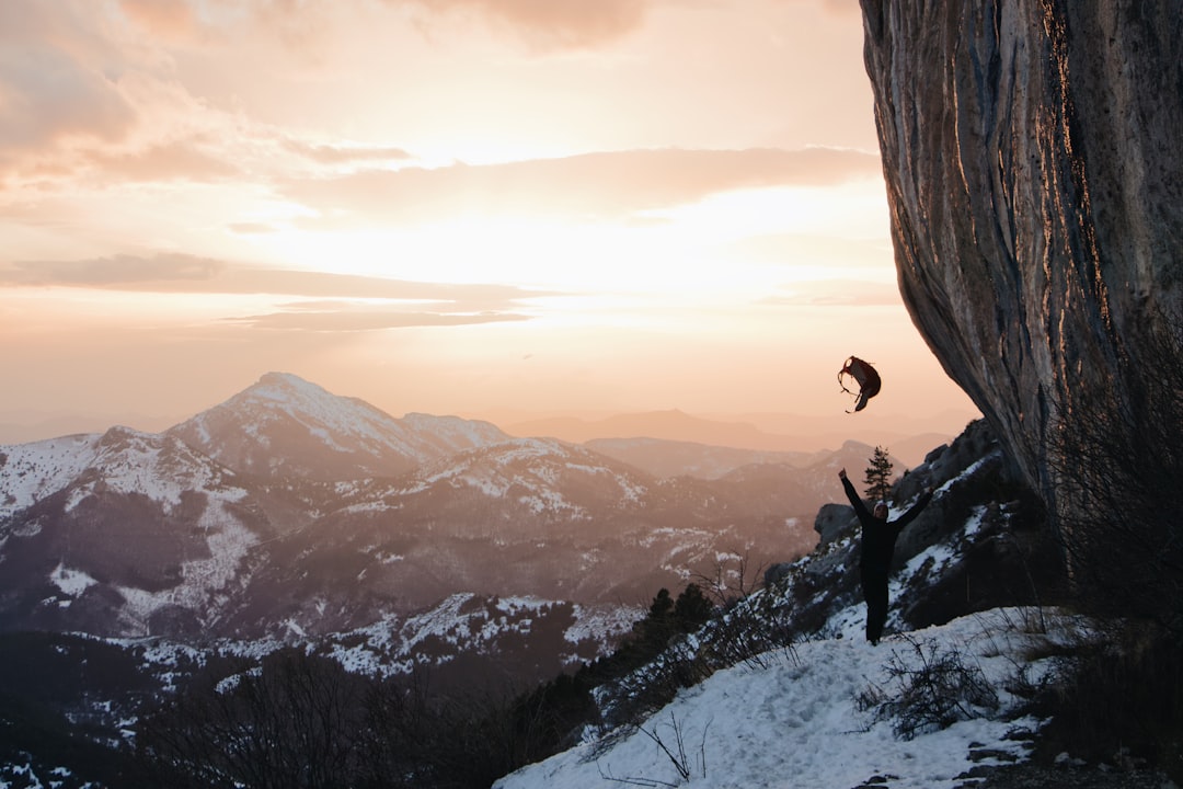 time-lapse photography of person in a mountain peak throwing his backpack