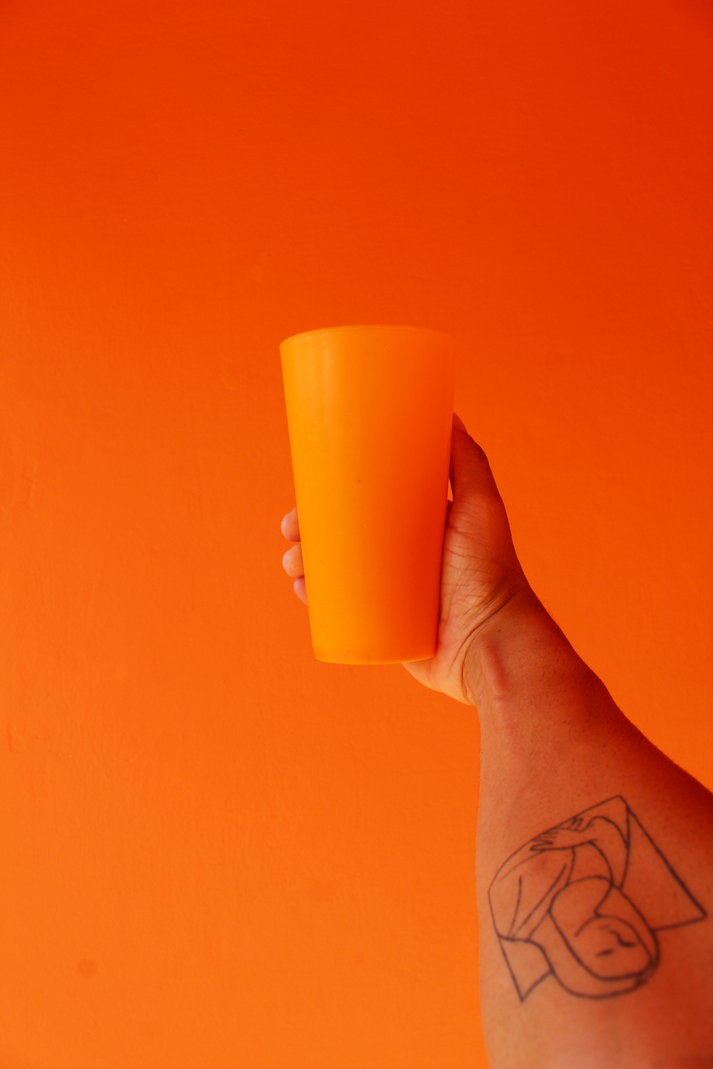 person holding orange cup