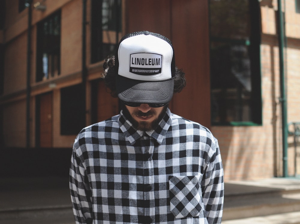 man wearing black, white, and gray plaid dress shirt