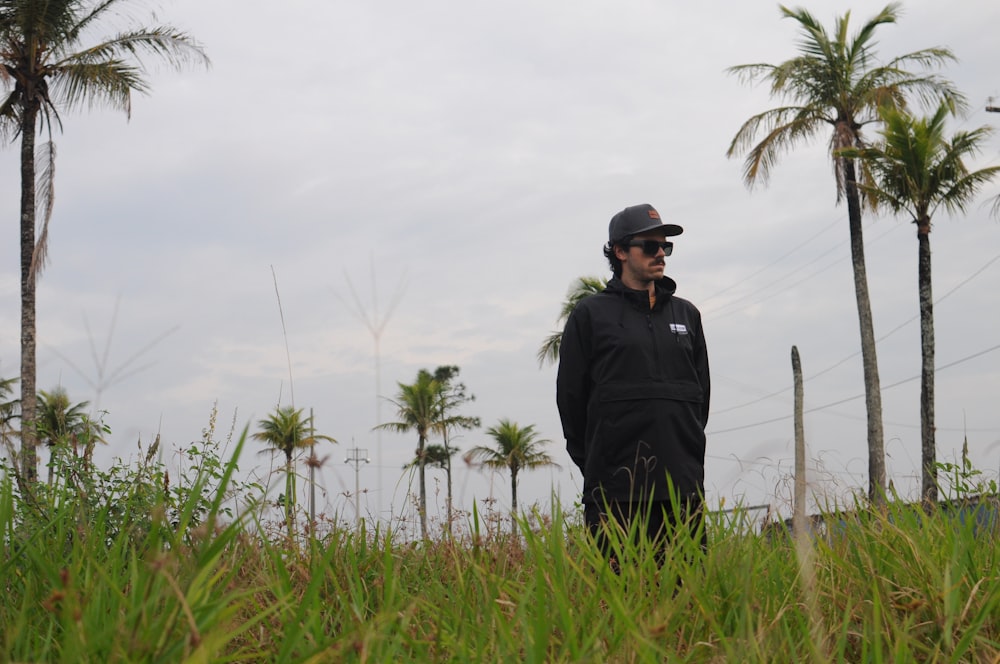 man standing in green grass during daytime