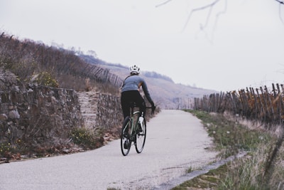 A cyclist enjoying a scenic ride through the rolling hills of Northern Lazio with vineyards in the background.